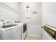 Well-lit laundry room with modern washer and dryer, wire shelving, and 'Laundry Room' sign at 1333 Maston Rd, Auburn, GA 30011