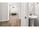 Stylish powder room featuring a pedestal sink, gold faucet, and decorative mirror at 1333 Maston Rd, Auburn, GA 30011