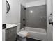Bathroom features gray tiled walls, a tub, and a modern vanity with a round mirror at 232 Mathewson Sw Pl, Atlanta, GA 30314
