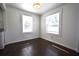 A bright living room with white walls, dark wood floors, and large windows with blinds at 232 Mathewson Sw Pl, Atlanta, GA 30314