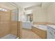 Bathroom features a glass shower, soaking tub with tan tile surround, double vanity sinks and tile floors at 2349 Harshaw Ave, Lawrenceville, GA 30043