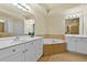 Bathroom featuring double vanity sinks, soaking tub, tile floors and two large mirrors with lights at 2349 Harshaw Ave, Lawrenceville, GA 30043