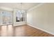 Open dining area featuring hardwood floors, chandelier lighting, and a glass pane door to the backyard at 2349 Harshaw Ave, Lawrenceville, GA 30043