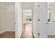 Hallway leading to closet and en-suite bathroom with dual sink vanity and open to sunlit bedroom at 2349 Harshaw Ave, Lawrenceville, GA 30043