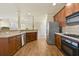Kitchen showcasing hardwood floors, stainless steel appliances, dark cabinets, and an open view of other living spaces at 2349 Harshaw Ave, Lawrenceville, GA 30043
