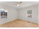 Bright bedroom featuring two windows, ceiling fan, and hardwood floors at 1428 Pinehurst Sw Dr, Atlanta, GA 30311