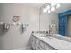 Elegant bathroom featuring granite countertops, white cabinets, and stylish lighting fixture at 1558 Amberwood Creek Nw Dr, Kennesaw, GA 30152