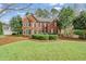 Charming brick home with lush lawn, showcasing classic architecture and mature trees at 1558 Amberwood Creek Nw Dr, Kennesaw, GA 30152
