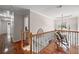 Upstairs hallway with wood floors, chair, and natural light at 1558 Amberwood Creek Nw Dr, Kennesaw, GA 30152