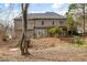 Rear of home with wooded landscaping, patio and small retaining wall at 1558 Amberwood Creek Nw Dr, Kennesaw, GA 30152