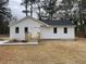 Charming single-story home with new white siding, black roof, and a wood porch at 5385 Booker T Dr, Morrow, GA 30260