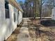 View of the side yard with a concrete walkway and new siding at 5385 Booker T Dr, Morrow, GA 30260