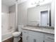 Bathroom with granite countertop, white cabinetry, and shower-tub combo at 5199 Mainstreet Park Dr, Stone Mountain, GA 30088