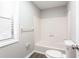 Cozy bathroom featuring a shower-tub combination and a bright window with white blinds at 5199 Mainstreet Park Dr, Stone Mountain, GA 30088