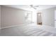 Bright bedroom showcasing new carpet, neutral paint, and a window allowing natural light at 5199 Mainstreet Park Dr, Stone Mountain, GA 30088