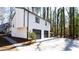 Rear view of a home with a two-car garage, showcasing modern siding and a well-kept driveway with adjacent trees at 5199 Mainstreet Park Dr, Stone Mountain, GA 30088