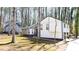 Charming home boasts updated siding and dark trim accents, surrounded by beautiful mature trees at 5199 Mainstreet Park Dr, Stone Mountain, GA 30088