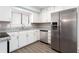 Updated kitchen features white cabinetry, stainless steel appliances, granite countertops and LVP flooring at 5199 Mainstreet Park Dr, Stone Mountain, GA 30088