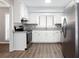 Modern kitchen with white cabinetry, stainless steel appliances, granite countertops and LVP flooring at 5199 Mainstreet Park Dr, Stone Mountain, GA 30088