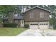 Charming two-story home featuring stone accents, a two-car garage, and a well-maintained front yard at 7356 Caribou Trl, Riverdale, GA 30296