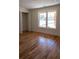 Sunlit bedroom with wood floors, closet, and a large window offering a neighborhood view at 1883 Bennett Rdg, Snellville, GA 30078