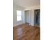 Well-lit bedroom features hardwood floors, a closet with folding doors, and a view through a large window at 1883 Bennett Rdg, Snellville, GA 30078