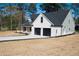 An exterior view showcasing the home's neutral siding and attached garage with sleek black doors at 1883 Bennett Rdg, Snellville, GA 30078