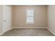 This is a cozy bedroom with neutral carpet, a window with blinds, and light-colored walls at 5589 Claridge Cir, Lithonia, GA 30038