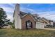 A side view of a well-maintained home with vinyl and brick siding, accented by a two-car garage at 5589 Claridge Cir, Lithonia, GA 30038