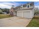 Side view of a two-story home with a two-car garage and a well-maintained front yard at 5589 Claridge Cir, Lithonia, GA 30038