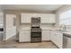 Bright kitchen features white cabinets, stainless steel appliances, and a modern design at 5589 Claridge Cir, Lithonia, GA 30038