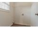 This is a laundry room featuring white walls, wood plank flooring, and a window with blinds at 5589 Claridge Cir, Lithonia, GA 30038