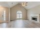 Open living room with vaulted ceilings, fireplace, and large windows filling the space with light at 5589 Claridge Cir, Lithonia, GA 30038