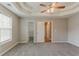 Large main bedroom features tray ceiling, a ceiling fan, and access to the ensuite bathroom at 5589 Claridge Cir, Lithonia, GA 30038