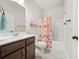 Bright bathroom featuring a dark wood vanity, white sink, decorative shower curtain and tub at 2316 Ridge View Dr, Loganville, GA 30052