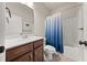 Bathroom with a sink, toilet, and a white tub shower, featuring a blue and white curtain at 2316 Ridge View Dr, Loganville, GA 30052