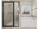 Updated bathroom featuring glass enclosed shower and separate tub with neutral color palette at 2316 Ridge View Dr, Loganville, GA 30052