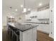 Well-lit kitchen with white cabinets, dark countertops, an island with bar stools, and hardwood floors at 2316 Ridge View Dr, Loganville, GA 30052
