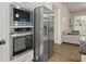 Stainless steel microwave, oven, and refrigerator in kitchen with hardwood floors leading to living area at 2316 Ridge View Dr, Loganville, GA 30052