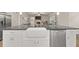 Kitchen island featuring a farmhouse sink, stainless steel dishwasher, white cabinets, and dark countertops at 2316 Ridge View Dr, Loganville, GA 30052