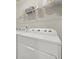 Functional laundry room with white washer and dryer and storage shelves overhead at 2316 Ridge View Dr, Loganville, GA 30052
