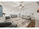 Open-concept living room with a kitchen view, ceiling fan, and plush area rug at 2316 Ridge View Dr, Loganville, GA 30052
