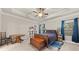 Comfortable bedroom featuring tray ceiling, fan, and dark blue curtains, with decoratively styled furniture at 2316 Ridge View Dr, Loganville, GA 30052