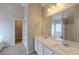 Well-lit bathroom featuring double sinks with a large mirror and wood-look flooring at 4060 Rockmill Cv, Ellenwood, GA 30294