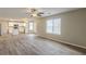 Open floor plan with hardwood floors, ceiling fan and connecting kitchen at 4060 Rockmill Cv, Ellenwood, GA 30294