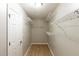 Walk-in closet with white shelving, a neutral color scheme, and wood-look flooring at 4060 Rockmill Cv, Ellenwood, GA 30294