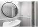 Bathroom featuring wainscoting, an updated vanity, a round mirror, and a modern faucet at 67 Blue Springs Sw Ct, Lilburn, GA 30047