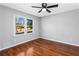 Bedroom with hardwood floors, ceiling fan, and a bright window overlooking the yard at 67 Blue Springs Sw Ct, Lilburn, GA 30047