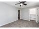 Grey bedroom featuring plush carpet, ceiling fan, and closet at 67 Blue Springs Sw Ct, Lilburn, GA 30047