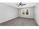 Bright bedroom with plush carpet, ceiling fan, and a view at 67 Blue Springs Sw Ct, Lilburn, GA 30047